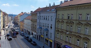 A street view with buildings, a tram, and parked cars. - MIlada Attic rooms (Prague)
