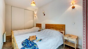 A bedroom with a wooden headboard, two bedside tables, a nightstand, a wardrobe, and a window with curtains. - Stay for 7 near Luchon-Superbagnères (Bagnères-de-Luchon)