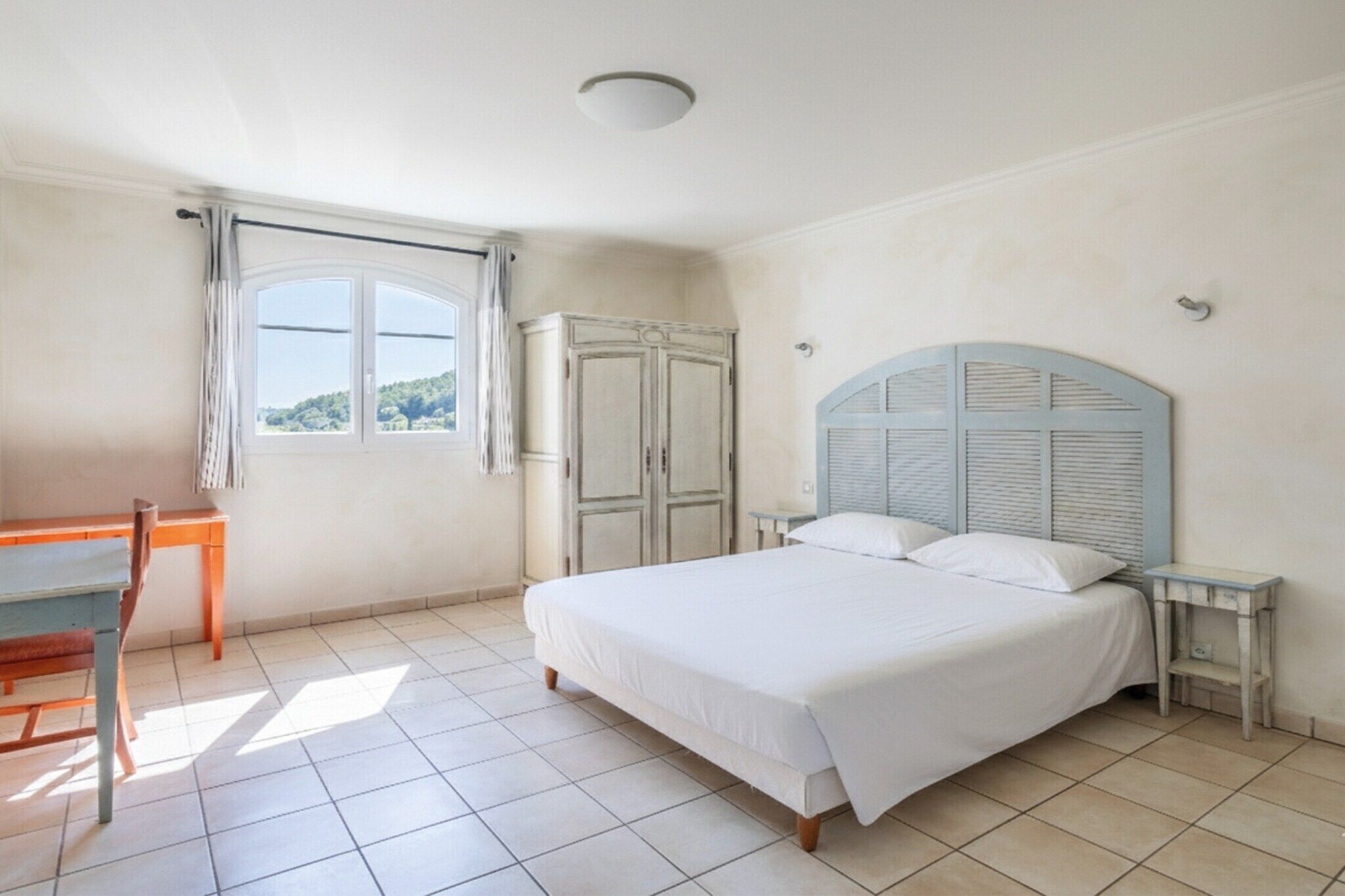 Ein Schlafzimmer mit Bett, Schreibtisch und Kleiderschrank.