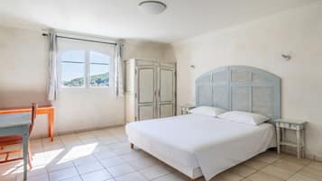 Ein Schlafzimmer mit Bett, Schreibtisch und Kleiderschrank.