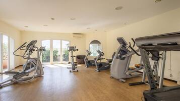 A gym with treadmills, elliptical machines, and a rowing machine.