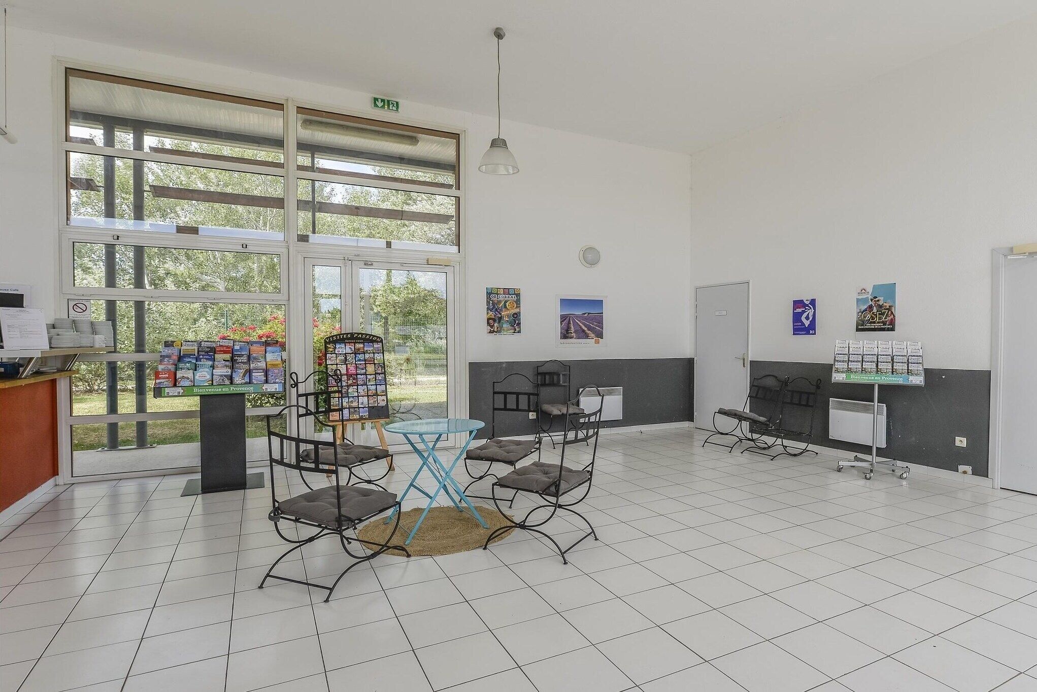 Un espace intérieur spacieux doté d’une grande fenêtre, d’une table avec des chaises, d’un tableau d’affichage et d’un distributeur automatique.