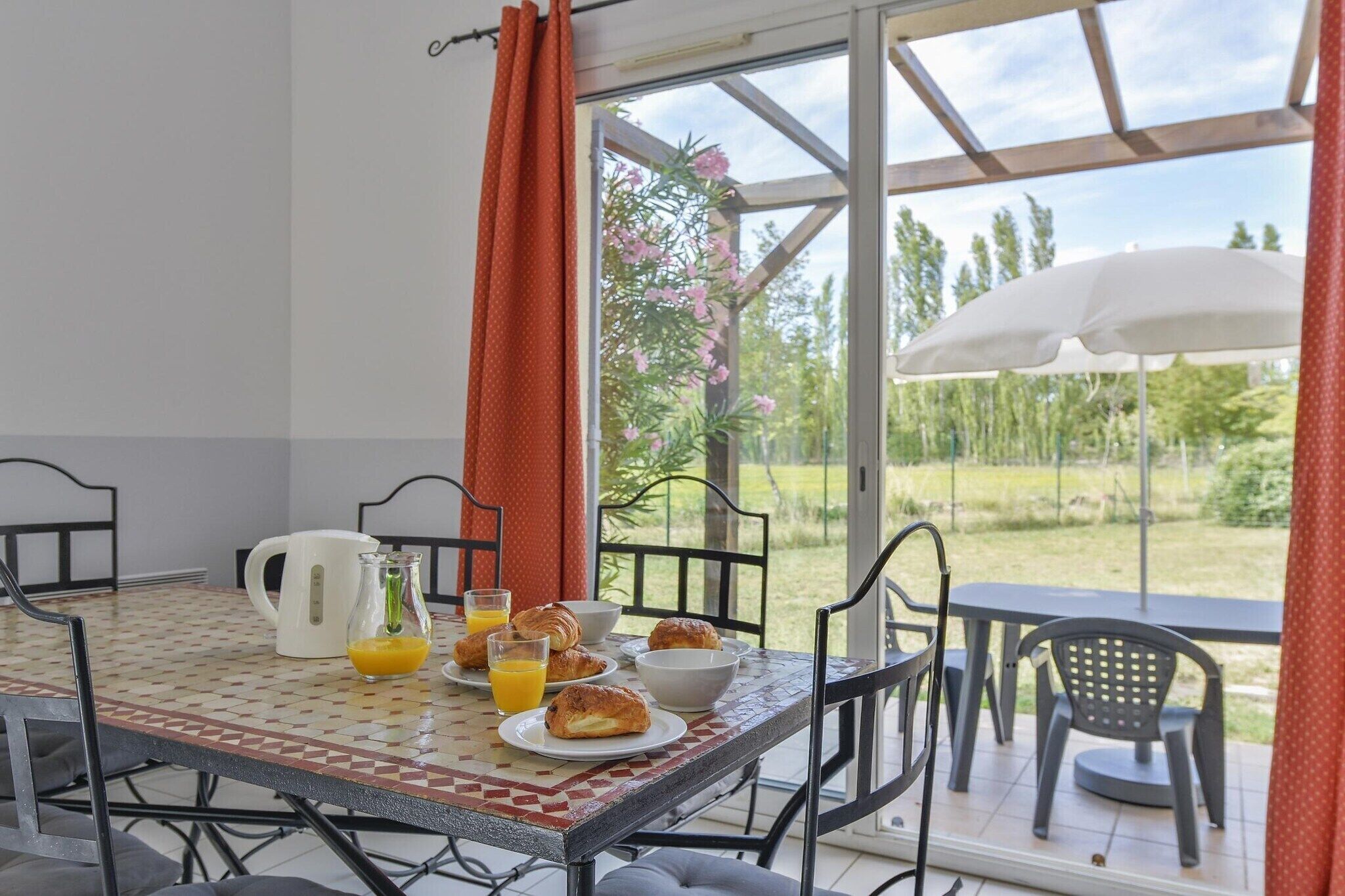 Et morgenbord med croissanter, appelsinjuice og en kaffekande.