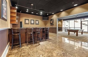 A bar area with a pool table, bar stools, and framed pictures on the wall. - Luxury High-Rise Condo w/ City Views Marta Bus & Train Access Free Parking (Atlanta)