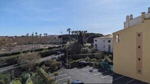 Ein Parkplatz mit mehreren Autos, ein Gebäude mit flachem Dach und einem klaren Himmel.