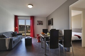 Un salon moderne comprenant un canapé, une table à manger, des chaises et un lit.