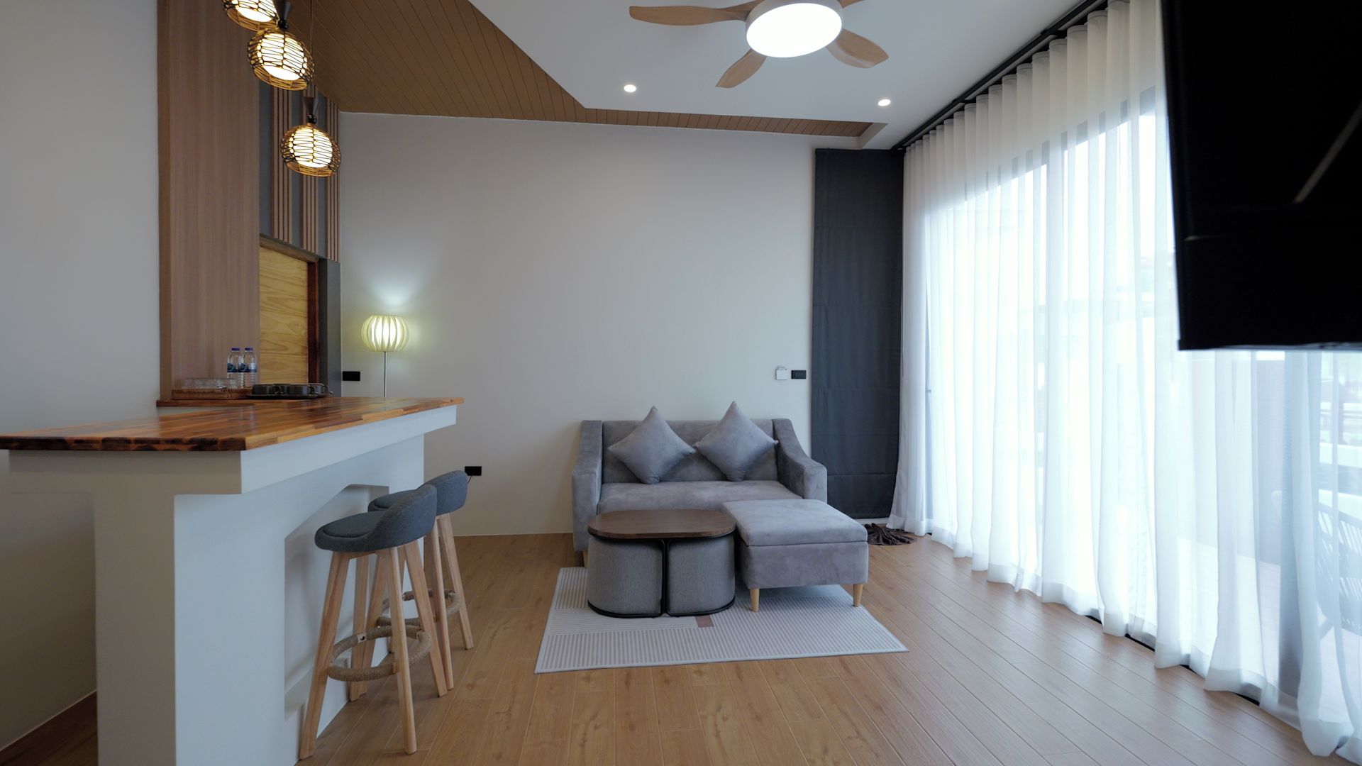 Ein modernes Wohnzimmer mit einer Couch, einem Couchtisch und einer Bar mit Hockern.