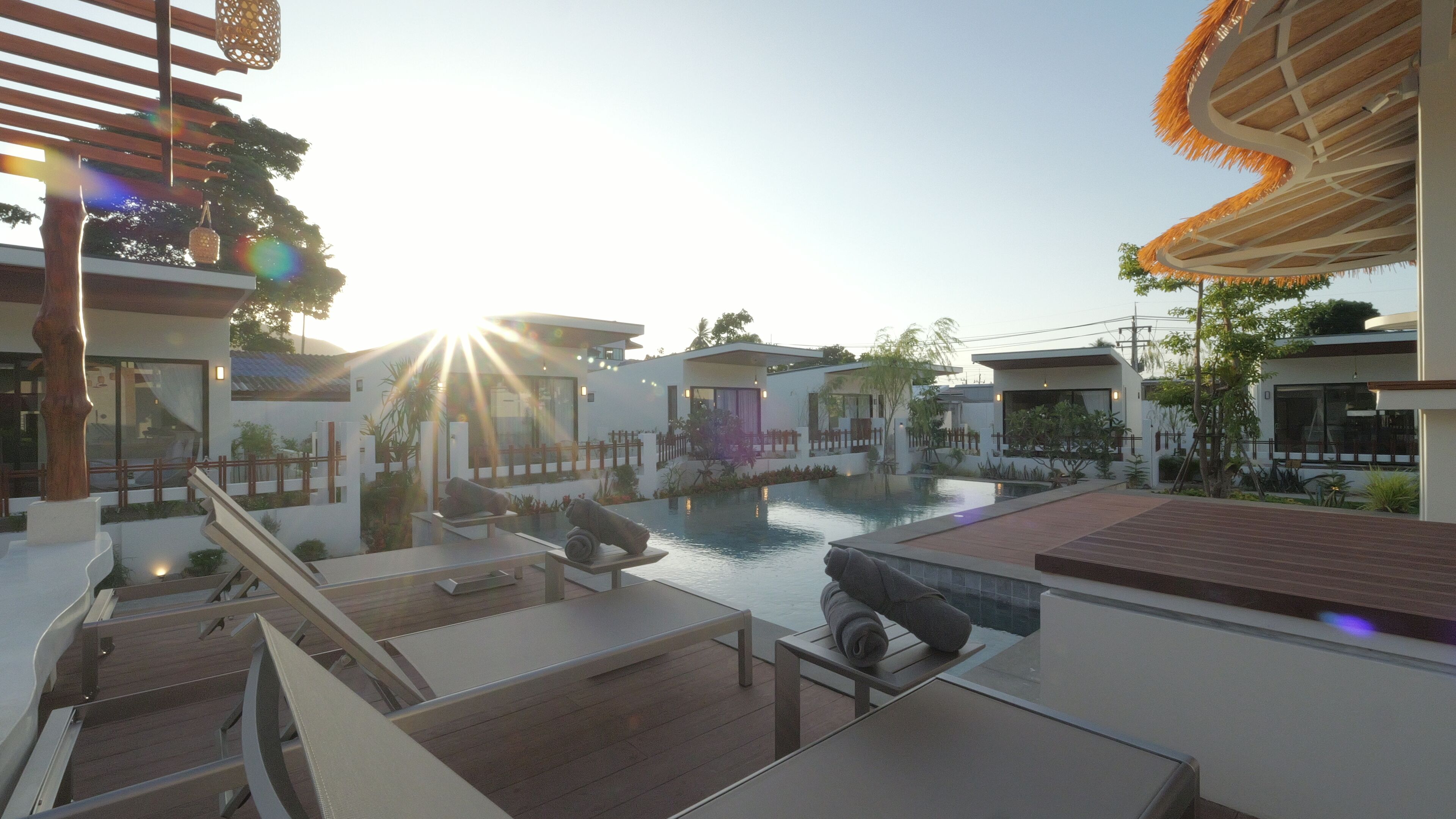 Un resort moderno con piscina, terraza de madera y arquitectura contemporánea.