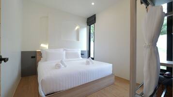 A modern bedroom with a large bed, a bedside table, a wall-mounted light, and a window with a view.