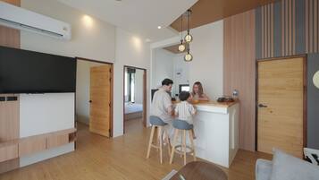Una cocina moderna con una isla central, suelo de madera e iluminación colgante.