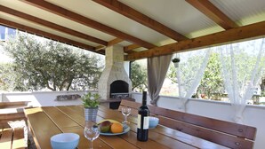 A wooden table with a bowl, wine glasses, and a bottle of wine. - Apartment with garden and BBQ area (Umag)