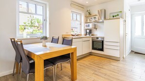 Eine moderne Küche mit einem Holzespeisetisch, Stühlen und integrierten Geräten.