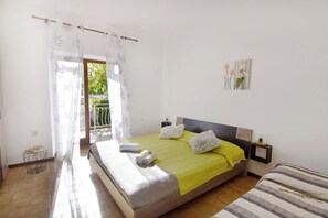 Une chambre à coucher comprenant un lit, une table de chevet, une commode, une fenêtre avec vue et une petite table avec des livres.
