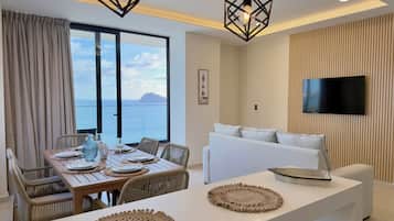 Suite Deluxe, balcón, vista a la playa | Sala de estar | Smart TV, piso con calefacción y oficina