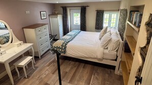 A bedroom with a bed, a desk, a dresser, and a window with curtains. - Langham House Cottage - A Tranquil West Devon Getaway (Liftondown)