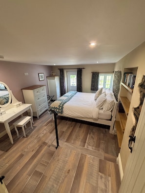 A bedroom with a bed, a desk, a dresser, and a window with curtains. - Langham House Cottage - A Tranquil West Devon Getaway (Liftondown)