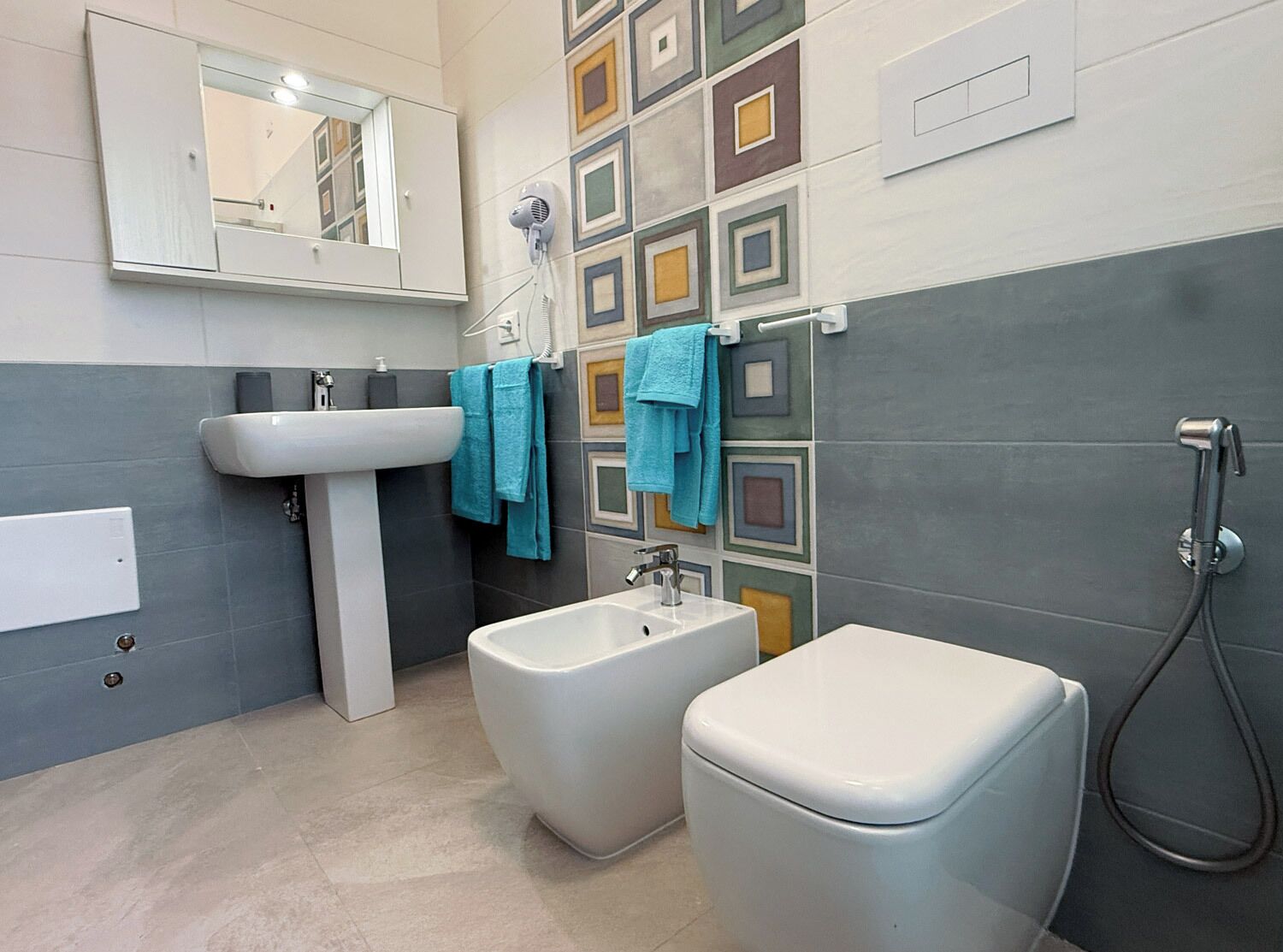 Et moderne badeværelse med et fritstående håndvask, bidet og en bruseniche.