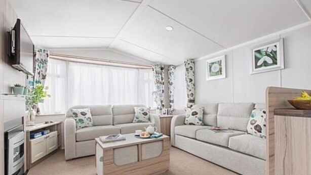 Ein modernes Wohnzimmer mit einer Couch, einem Couchtisch und einem Fernseher.