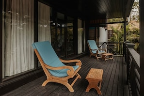 A wooden deck with two wooden lounge chairs and a small wooden table.
