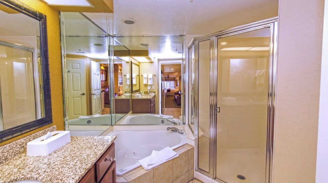 A bathroom with a bathtub, a shower, and a large mirror.