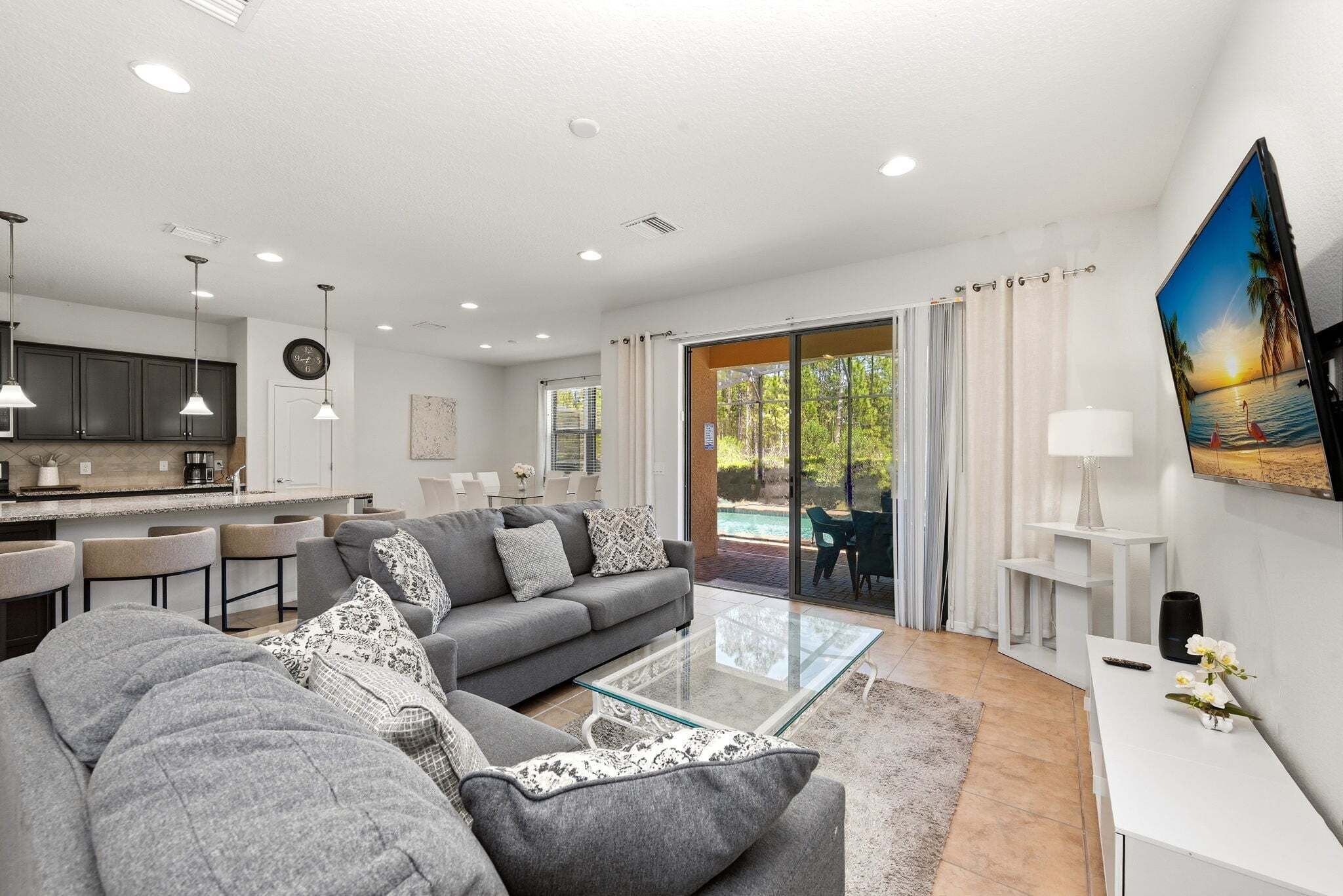 A modern living room with a sofa, coffee table, and a dining area with chairs.