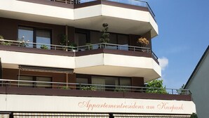 Un edifici de diverses plantes amb balcons, un rètol que diu 'Appartementresidenz am Kurpark' i el número de carrer visible '49'.
