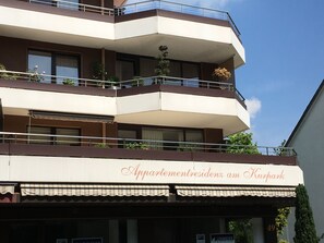 A multi-story building with balconies, a sign reading 'Appartementresidenz am Kurpark,' and a visible address number '49.' - Vacation Rental Near the Spa Park with a Pool, Sauna, and Garage (Bad Salzuflen)
