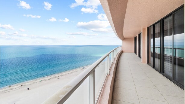Un balcón con vista a la playa y al océano.