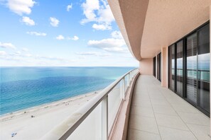 Un balcon avec vue sur la plage et l’océan.
