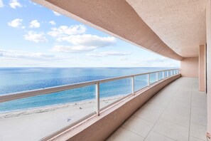 Ein Balkon mit Blick auf das Meer und den Strand.