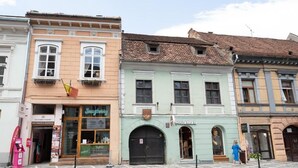 Eine Reihe historischer Gebäude mit Geschäften, darunter ein Restaurant und ein Bekleidungsgeschäft.