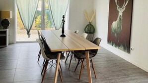 A dining area with a wooden table and chairs, a pendant light, and a deer painting on the wall. - Private villa with pool and garden (Ollioules)