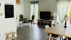 A modern living room with a dining area, a television, and a chalkboard sign. - Private villa with pool and garden (Ollioules)