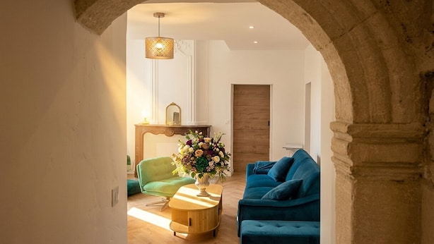 Una sala de estar con un sillón verde, un sofá azul y una mesa de centro de madera.