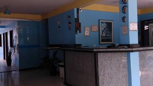 A reception area with a counter, blue walls, and ceiling lights. - HOTEL LAGOA AZUL (Porto Seguro)