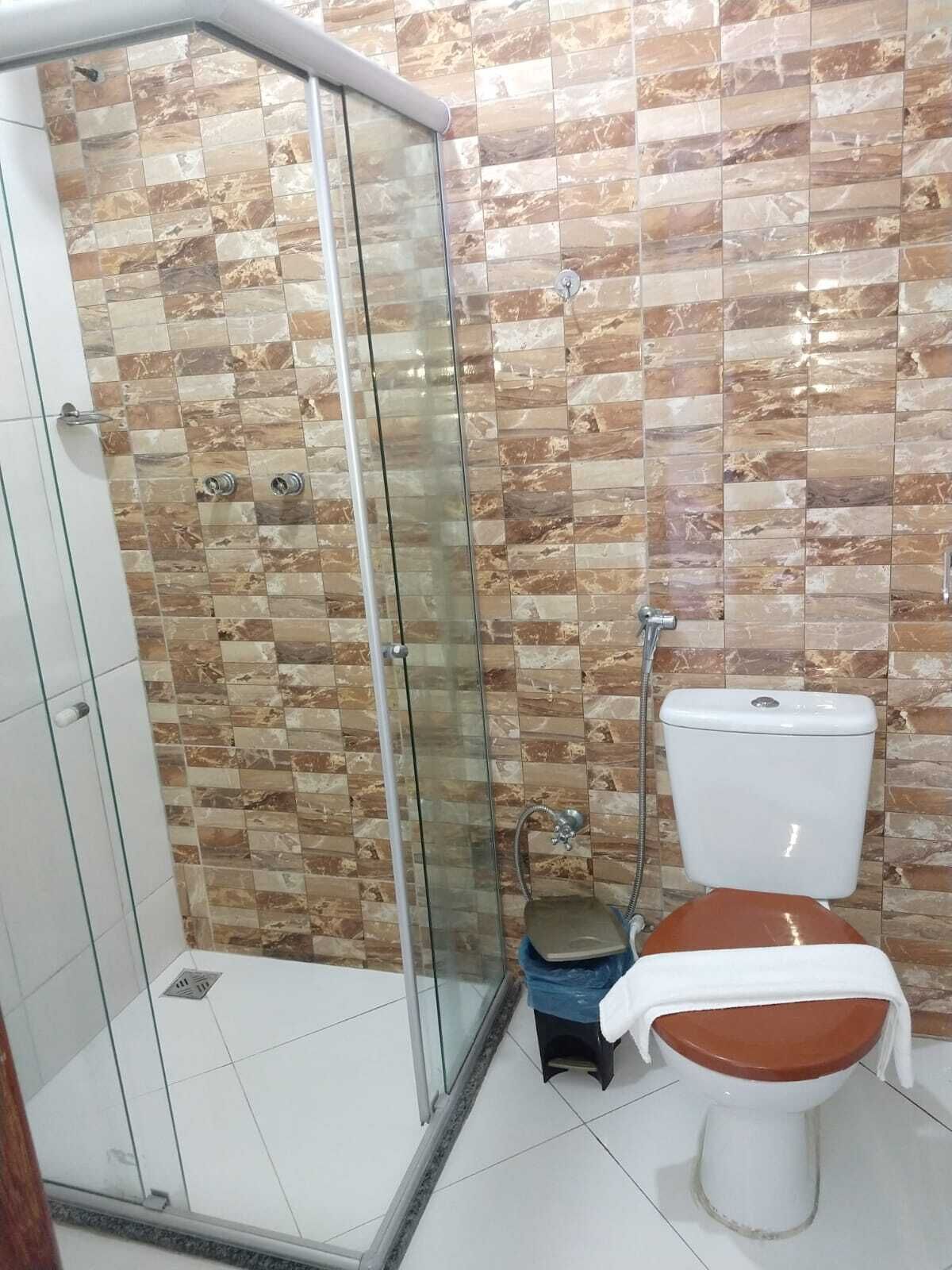 Chuveiro, toalhas de banho, papel higiênico 
