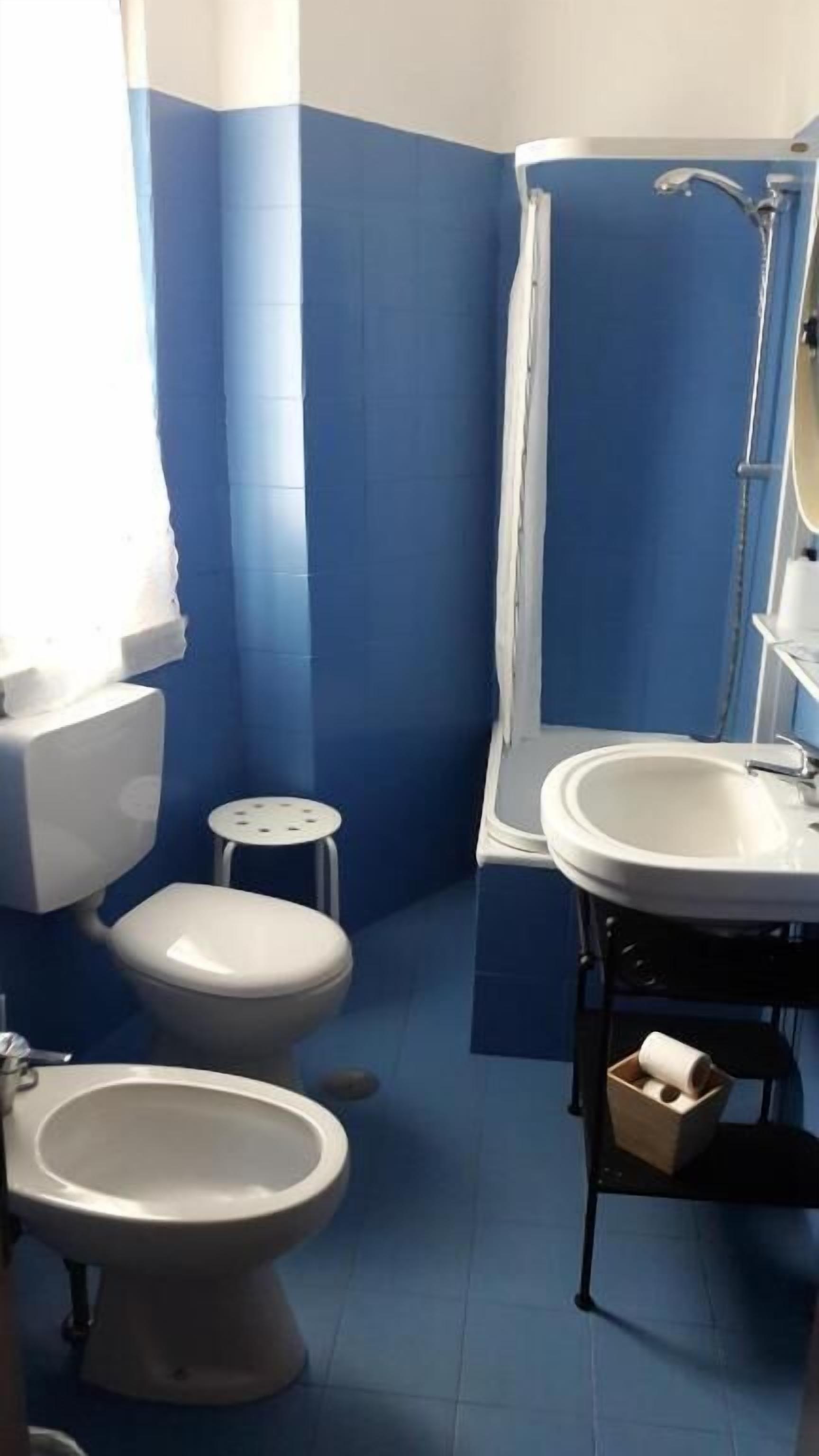Une salle de bain équipée de toilettes, d’un bidet et d’un lavabo.