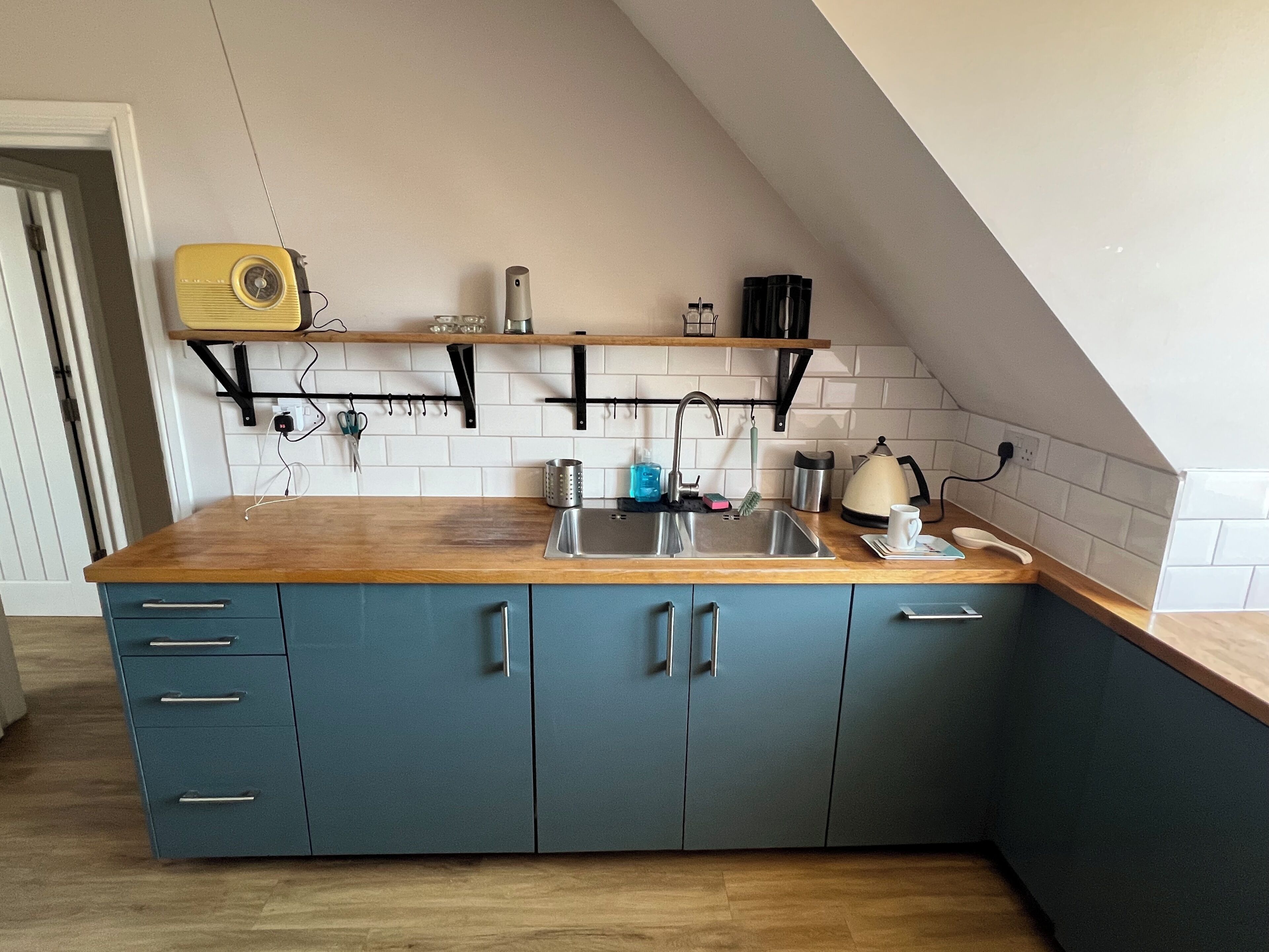 A kitchen with a wooden countertop, a sink, and cabinets.