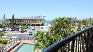 Un hotel con piscina, estacionamiento y vista al océano.