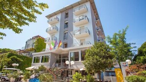 Un hôtel à plusieurs étages doté de balcons, d’un escalier et d’un espace extérieur aménagé pour s’asseoir.