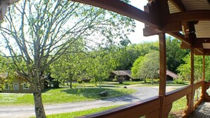 A wooden deck with a view of a residential area, including houses and trees.