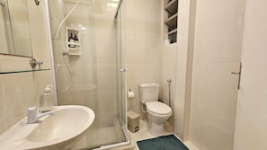A bathroom with a glass shower enclosure, a toilet, and a sink. - Copacabana Breeze Studio, 5 minutes from the beach (Rio de Janeiro)