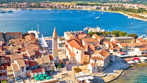 An aerial view of a coastal town with a prominent church, narrow streets, and a marina with boats. - Cozy and Practical Studio in Šćavonija (Umag)