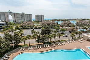 Ein Resort mit Pool, Palmen und Blick auf den Ozean.