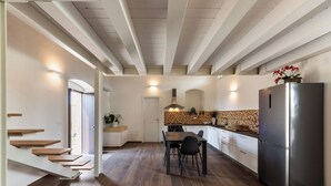 Eine moderne Küche mit Essbereich, Holzboden und einem Edelstahl-Kühlschrank.