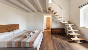 Ein Schlafzimmer mit einem hölzernen Bett, einer Treppe und einem Fenster.