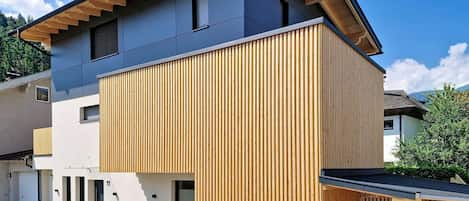 A modern two-story house with a wooden facade and a sloped roof.
