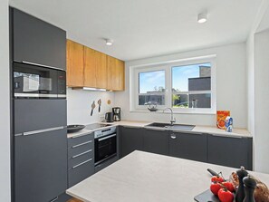 Eine moderne Küche mit Mikrowelle, Backofen und Kaffeemaschine.