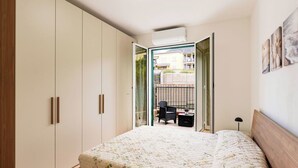 Una camera da letto con un letto, un armadio e vista su un balcone con mobili da esterno.