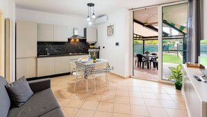 Una cucina moderna con zona pranzo, divano e vista sul giardino.